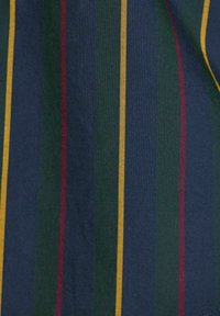 Vertikálne pruhy v tmavomodrej, zelenej, námorníckej, gaštanovej a žltej farbe na textúrovanom látkovom povrchu.