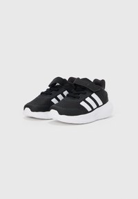 Črni atletski čevlji z zgornjim delom iz zračne mreže, belimi poudarki, nastavljivim trakom in oblazinjanim belim podplatom.