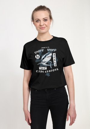 Černé bavlněné tričko s grafickým potiskem, na kterém je žralok, tučný text a detaily. Krátké rukávy, kulatý výstřih a volný střih.