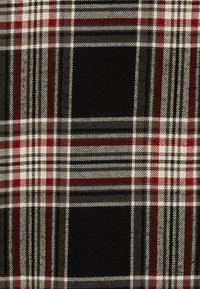 Tejido de cuadros que presenta colores negro, blanco, rojo y gris. El patrón incluye rayas y cuadros que se intersectan con una textura suave.