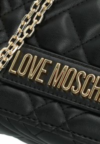 Borsa a tracolla nera trapuntata con dettagli in oro, con la scritta "LOVE MOSCHINO" stampata su un'etichetta in pelle e una tracolla in catena dorata.