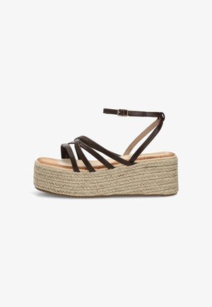 Sandalia marrón de cuero con tiras, hebilla en el tobillo y suela plataforma beige tejida.