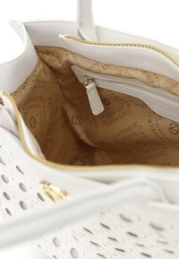 Borsa intrecciata bianca con chiusura a cerniera. L'interno presenta una fodera beige con loghi ripetuti e una tasca con cerniera aggiuntiva per riporre oggetti.