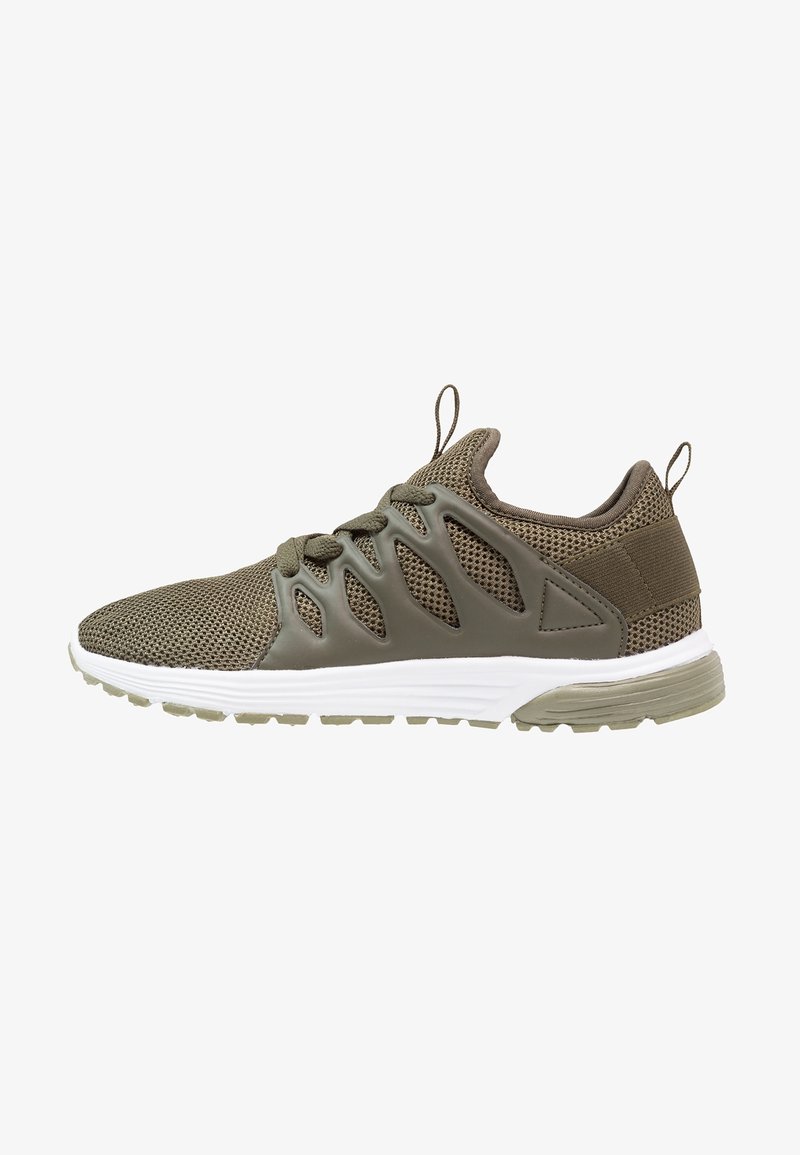 Chaussure de sport en mesh vert olive avec supports latéraux en plastique découpés, fermeture à lacets, languettes de traction et semelle blanche rembourrée.