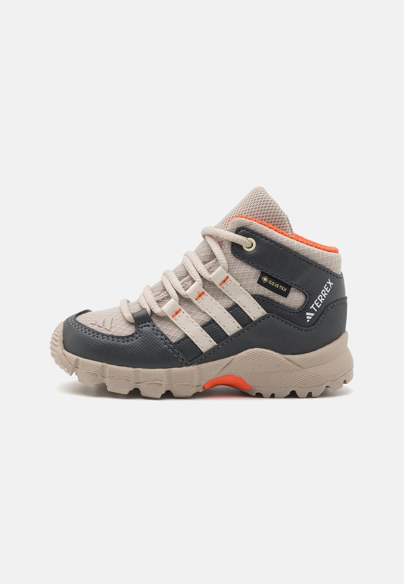 Beige and dark gray hiking shoe with a textured surface, rubber sole, and metallic eyelets. Features orange accents and five lace loops.