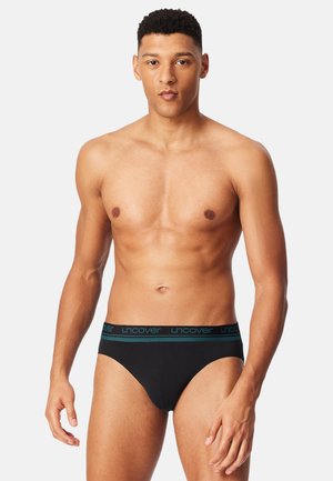 Mutandine di cotone nere con elastico in vita a contrasto color teal con il logo "uncover". Design aderente con texture liscia e copertura minima.