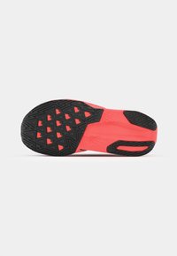 Semelle de chaussure avec une surface texturée noire et des accents corail vif. Présente des motifs triangulaires pour l'adhérence et une forme incurvée pour la flexibilité.