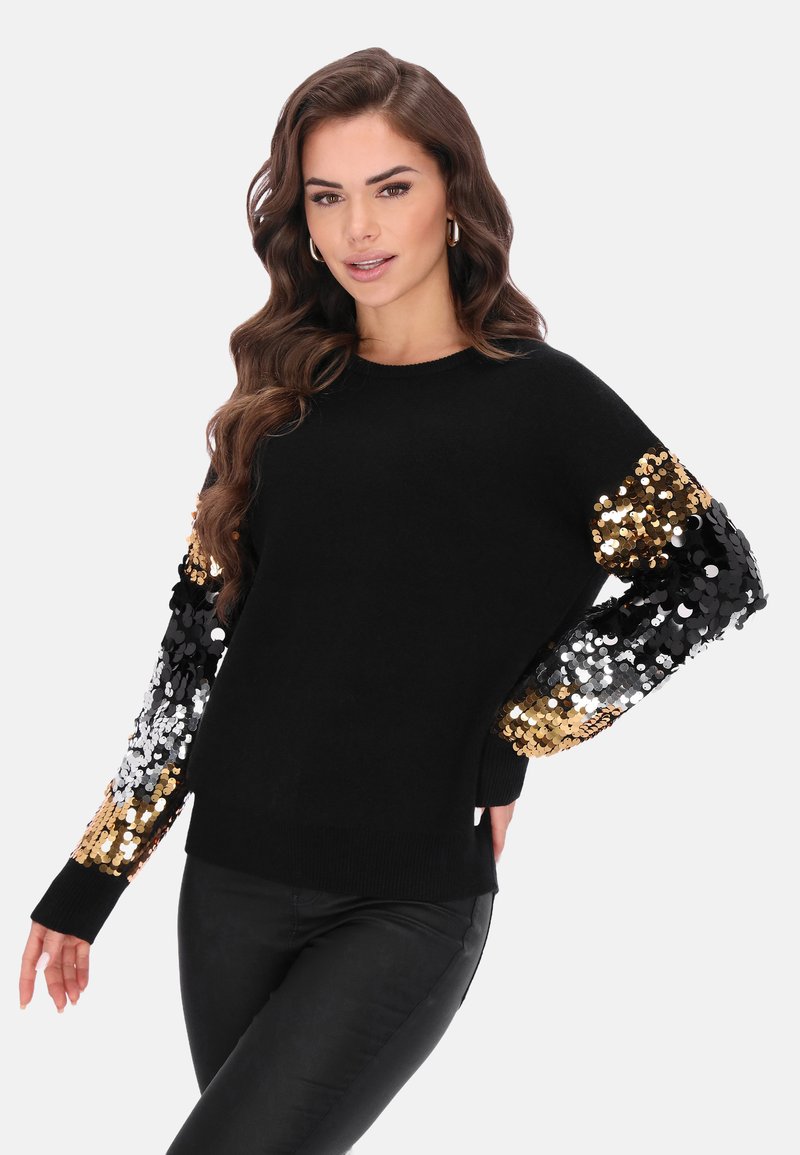 Schwarzer Pullover mit langen Ärmeln, verziert mit goldenen und silbernen Pailletten. Weiches Material, rundhalsausschnitt und enganliegende Bündchen.