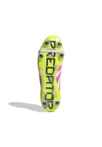 Bottines de football avec une semelle jaune vif et un marquage "PREDATOR" noir, des accents roses et six crampons métalliques pour l'adhérence.