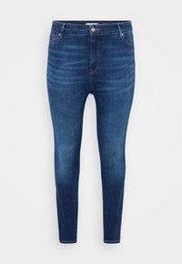 Skinny jeans made of dark blue denim, featuring a classic five-pocket design, button closure, and subtle faded detailing.
