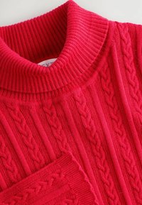 Roter Strickpullover mit hohem, geripptem Kragen und vertikalen Zopfmuster. Weicher Griff und detaillierte Rippen am Saum und an den Bündchen.