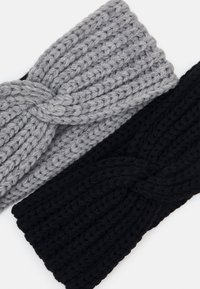 Dos diademas de punto, una gris y otra negra, con patrones texturizados y un detalle de nudo retorcido en la parte frontal.