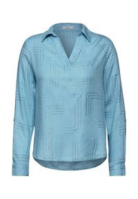 Camicetta azzurra a maniche lunghe con scollo a V, caratterizzata da un motivo geometrico a righe. Realizzata in tessuto morbido con un orlo leggermente curvo e polsini con bottoni.