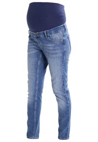 Modré těhotenské džíny se strečovým páskem v námořnické barvě, zakrývající břicho, vystavené na bílém pozadí.