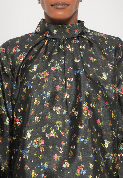 Blusa nera a fiori con colletto alto, caratterizzata da vivaci motivi floreali, una texture setosa e dettagli arricciati attorno allo scollo.