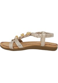 Vlakke sandaal in metallic zilver met gevlochten banden en gele bloemenaccenten. Gevoerde voetbed en flexibele beige zool.