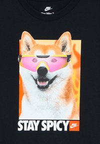 Shiba Inu šuo, dėvintis rožinius sportinius akinius su oranžine liepsna fono ir tekstu „LIKITE AŠTRŪS“ su „Nike“ logotipu juodame audinyje.