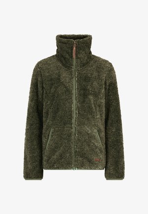 Une fille souriante porte une veste polaire vert olive, un pantalon noir à motifs d'étoiles et des bottes de neige noires sur un fond blanc.
