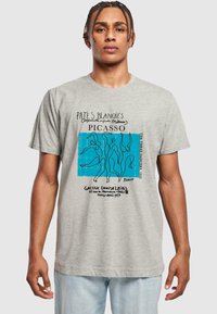 Graues T-Shirt mit kurzen Ärmeln, das ein blaues abstraktes Design mit umrandeten Figuren und Text zeigt, hergestellt aus einem weichen Baumwollmischgewebe.