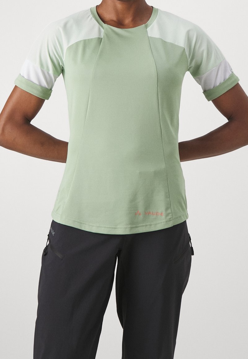 Vaaleanvihreä lyhythihainen urheilupaita, jossa on valkoisia yksityiskohtia ja teksturoitu kangas. Suunniteltu mukavuutta ja liikkuvuutta varten.