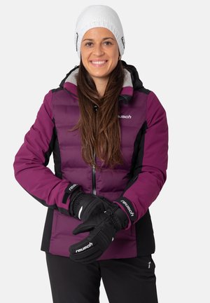 Lila gepolsterte Jacke mit schwarzen Akzenten, Reißverschluss vorne, hohem Kragen und angeschlossenem Kapuzen. Schwarze Handschuhe mit Logodetail. Weiße Strickmütze.