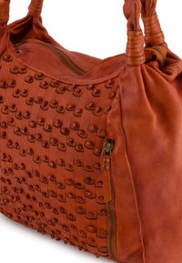 Lederhandtasche in tiefem Orange mit gewebter Textur, mit runden Nieten. Reißverschluss auf einer Seite und gerollte, texturierte Tragegriffe.
