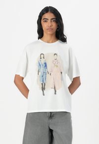 White cotton t-shirt featuring a front print of two fashion illustrations in blue and pink, with short sleeves and a relaxed fit.
