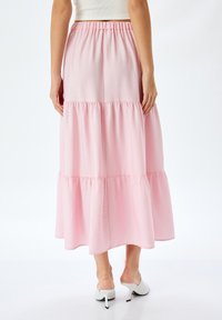 Gonna maxi rosa a strati con vita elasticizzata. Tessuto morbido con una texture liscia e una silhouette fluida. Design semplice e femminile.