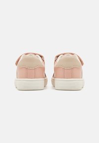 Roze leren sneakers met een beige hak, witte rubberen zolen en een gestructureerde roze riem. Kenmerkt een strakke uitstraling en subtiele stikseldetails.