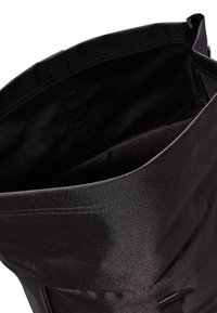 Fekete textil táska sima felülettel, redőzött kialakítással és látható varrással, tágas belső térrel.
