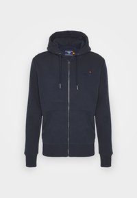 Sudadera con cremallera de color azul marino, con cordones, bolsillos frontales, puños y dobladillo acanalados, y pequeño logo bordado en el pecho.