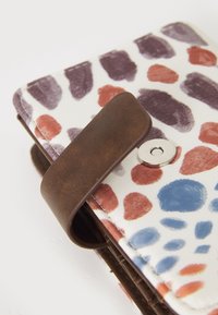 Portafoglio multicolore realizzato in materiale sintetico con un motivo astratto in viola, blu e rosso. Cinturino in pelle marrone con chiusura a scatto in metallo.