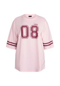 Ružové oversize tričko s krátkymi rukávmi, obsahuje bordový grafický motív "08" a text "PARIS" a dve bordové pásiky na každom rukáve.