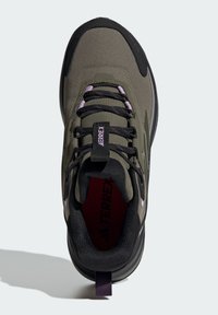 Green synthetic hiking shoe with black accents, textured upper, purple laces, and a pull tab; featuring padded collar and cushioned sole.