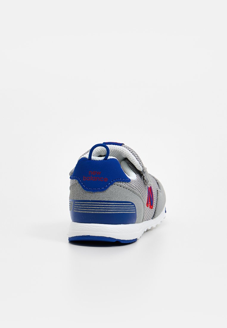 Zapatilla deportiva gris con parte superior de malla, detalles en azul y logo en rojo. Cuenta con un talón acolchado y suela de goma texturizada para mayor agarre.