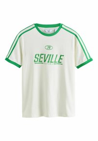 Bílé tričko s zelenými akcenty, na kterém jsou grafiky "SEVILLE" a "79". Krátké rukávy a žebrovaný kulatý výstřih se pruhy.