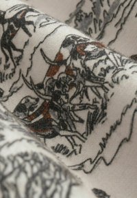 Tessuto morbido con dettagliate illustrazioni di animali neri e marroni, raffiguranti cani in varie posizioni, su uno sfondo beige chiaro.