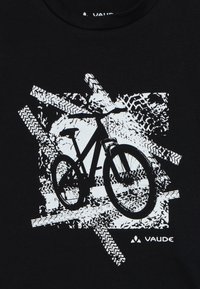 Melnā T-krekla dizains ar baltu velosipēda grafiku, kas izvietota starp abstraktiem riepu zīmējumu rakstiem. "VAUDE" logo baltā krāsā drukāts apakšējā labajā stūrī.