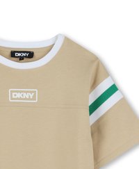 T-shirt beige avec un col rond blanc, arborant un logo DKNY. Les manches courtes sont ornées de rayures vertes et blanches. Fabriquée en tissu doux et lisse.