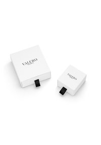 Hvide gaveæsker med sorte båndhåndtag, der bærer "VALERO PEARLS" logoet i sort skrift, en stor og en lille, rektangulær form.