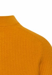 Rippstrick-Sweater aus senfgelbem Stoff mit hohem Kragen, der eine weiche Textur und eine Nahtdetail an der Schulter für eine enganliegende Passform aufweist.