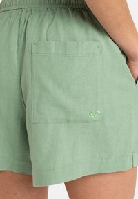 Lichtgroene linnen shorts met een relaxte pasvorm, een elastische tailleband en een achterzak met een geborduurd hartlogo.