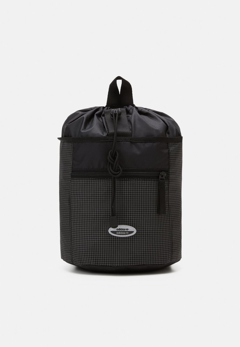 Black drawstring backpack with a grid pattern, featuring a front zip pocket and a logo patch. Made from durable nylon material.