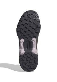 Suola in gomma nera con un profondo modello di battistrada, caratterizzata da lugs angolari per una migliore aderenza. La soletta testurizzata di colore chiaro contrasta con la parte inferiore scura.