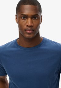 T-shirt bleu marine à col ras du cou en tissu doux et lisse. Caractéristiques : manches courtes et coupe classique. Simple et de couleur unie sans motifs.