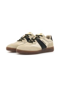 Sneakers beige in suede con un design in mesh testurizzato, accenti neri, lacci neri glitterati e una suola in gomma marrone. Nome del marchio sul lato.
