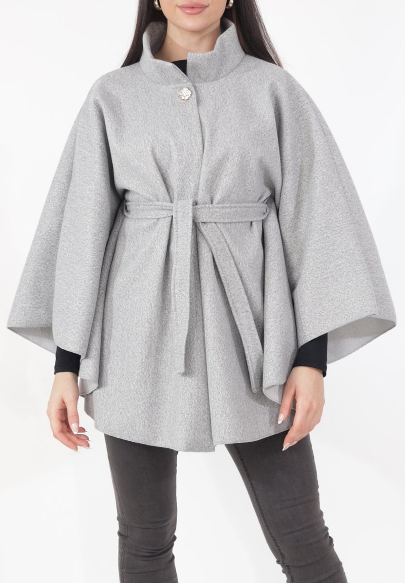 Grijze oversized mantel van een wolmix met een hoge kraag, een ceintuur met strik en een enkele decoratieve knoop. Heeft brede mouwen en een gestructureerde afwerking.