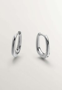 Pendientes de aro de plata con un diseño redondeado y suave, con un acabado pulido y un mecanismo de cierre visible.