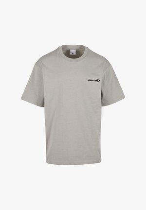 Tricou din bumbac gri, cu guler rotund, mâneci scurte și un mic logo negru "KARL KANI" în zona stângă a pieptului. Design simplu, croială casual.
