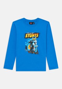 Langärmliges blaues T-Shirt aus Baumwolle, mit einem Grafikmotiv eines Lego-Charakters auf einem Motorrad und dem Text "Ich mache meine eigenen STUNTS."